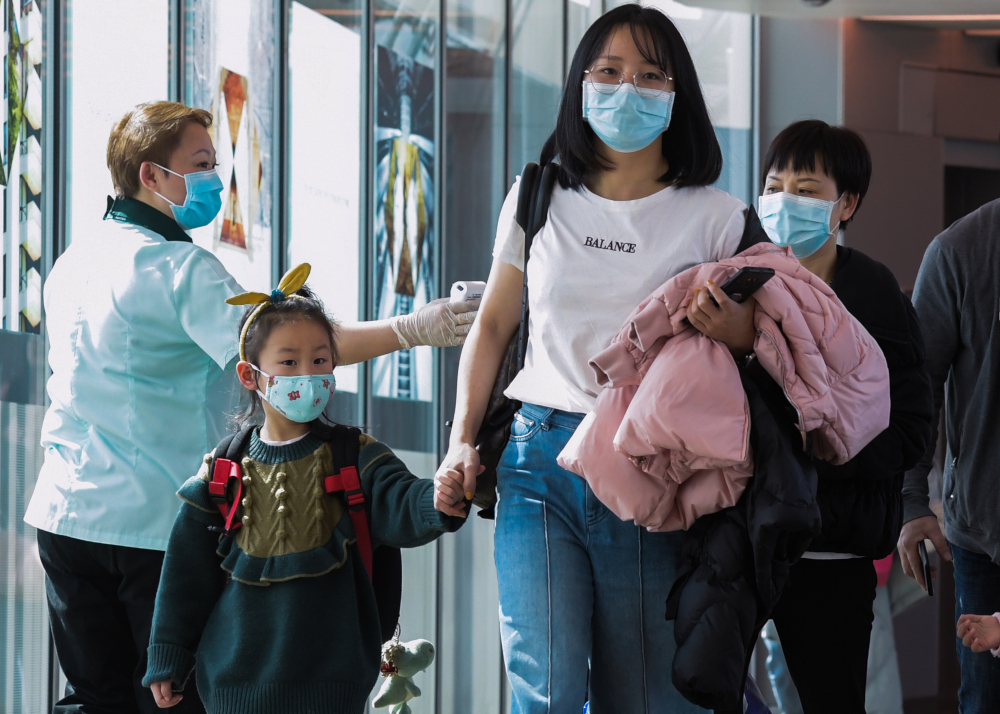 A health officer (left) screens arriving passengers from China at Changi International airport in Singapore January 22, 2020 as authorities increased measure against coronavirus. u00e2u20acu201d AFP pic 