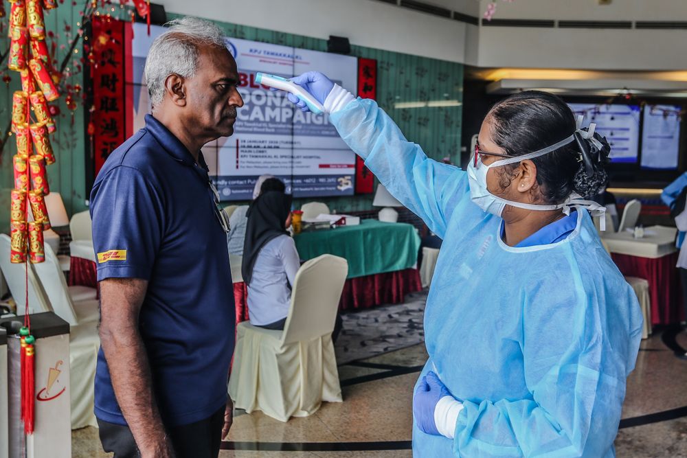 Medical personnel check the temperature of a visitor at the entrance of KPJ Tawakkal hospital in Kuala Lumpur, January 28, 2020. u00e2u20acu201d Picture by Firdaus Latif