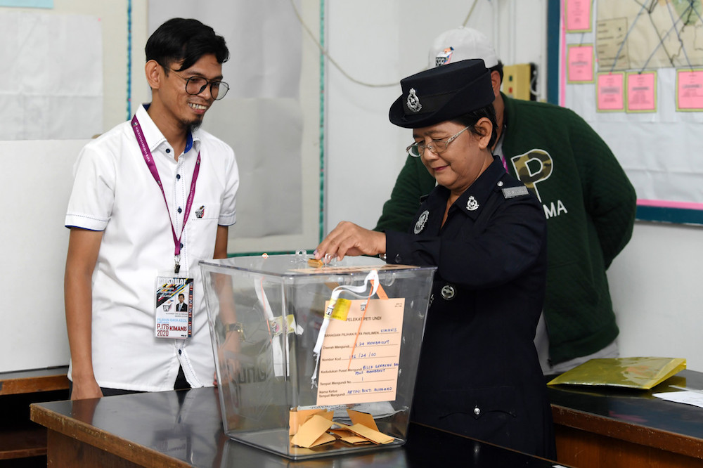 Corporal Dayang Gapah casts her ballot during early voting for the Kimanis by-election at Membakut police station January 14, 2020. u00e2u20acu201d Bernama pic