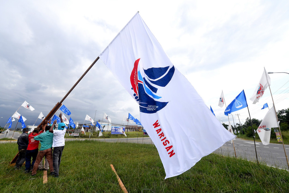 Warisan campaign workers put up flags in Kimanis January 8, 2020, ahead of the Kimanis by-election. u00e2u20acu201d Bernama pic