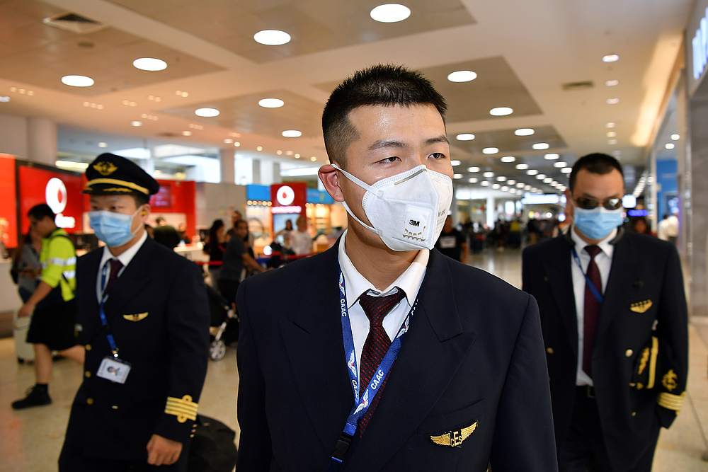 China Eastern Airlines flight crew wear protective masks on arrival at Sydney International Airport, Australia January 23, 2020. u00e2u20acu201d AAP Image/Joel Carrett via Reuters