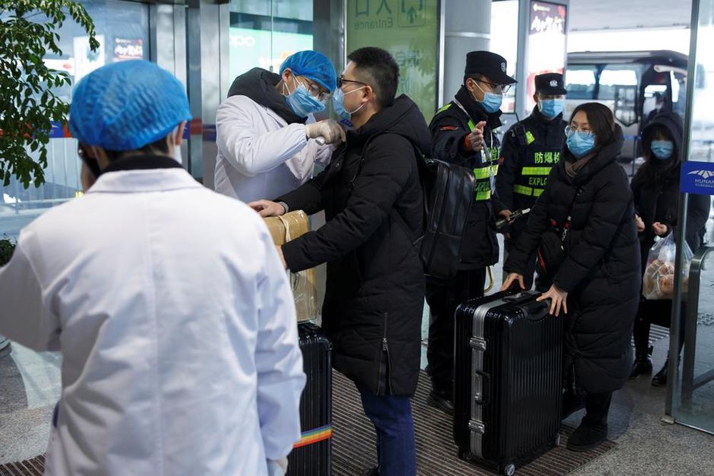 A medical official takes the body temperature of a man at the departure hall of the airport in Changsha, Hunan Province, as the country is hit by an outbreak of a new coronavirus, China, January 27, 2020. u00e2u20acu201d Reuters pic