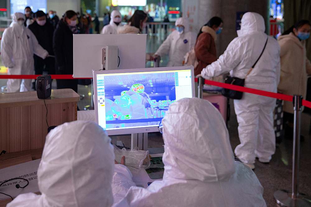 Workers in protective suits monitor a screen showing the thermal scan to check temperatures of passengers arriving at the Nanjing Railway Station, China January 27, 2020. u00e2u20acu201d cnsphoto via Reuters