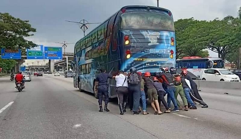 With the help of motorists, the Johor Baru Utara traffic police tried to move the bus at Km12 of Jalan Johor Baharu-Air Hitam but failed as the rear wheels had jammed. u00e2u20acu201d Picture via Facebook/Police Daerah Johor Bahru Utara