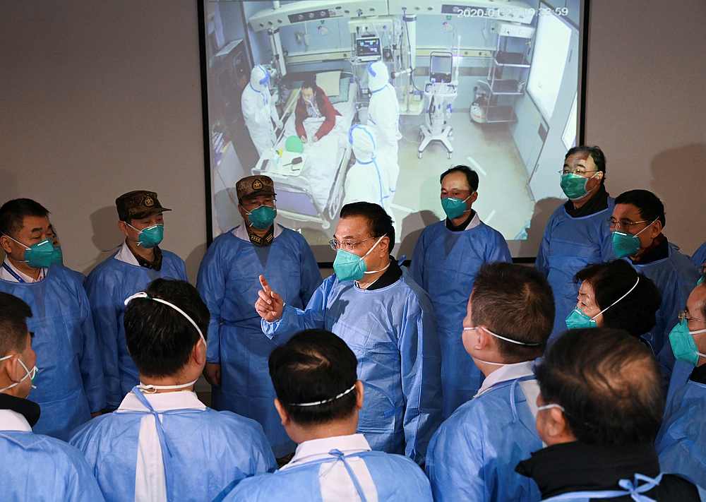 Chinese Premier Li Keqiang wearing a mask and protective suit speaks to medical workers as he visits the Jinyintan hospital in Wuhan, Hubei province January 27, 2020. u00e2u20acu201d cnsphoto via Reuters