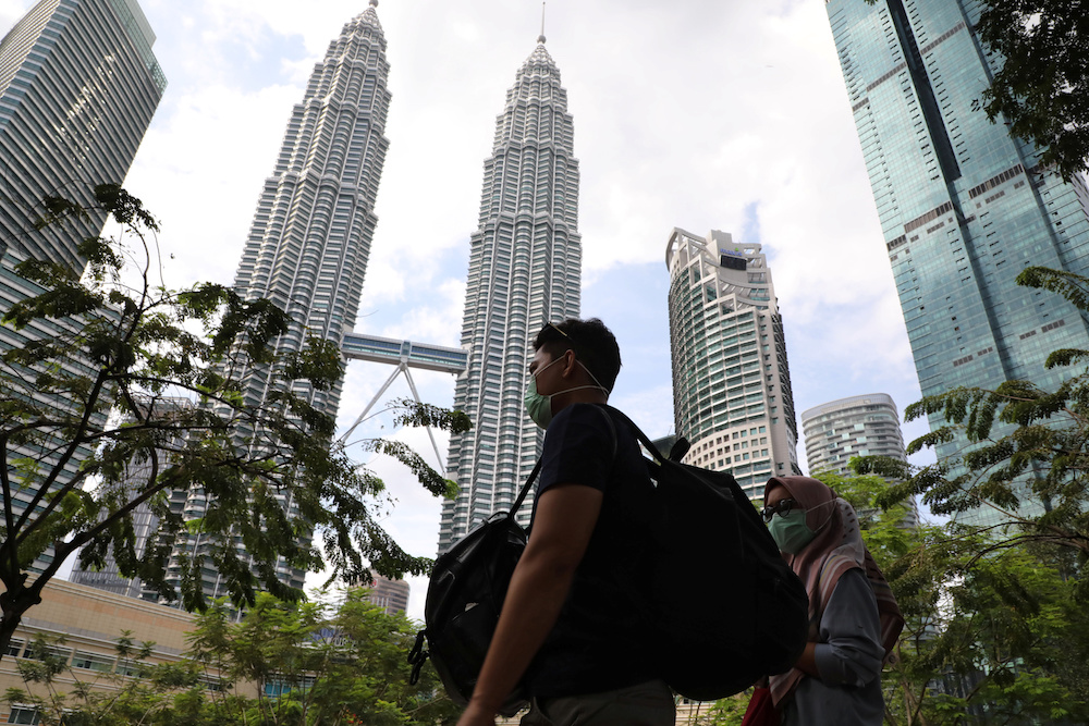 People wearing masks pass by Petronas Twin Towers in Kuala Lumpur January 31, 2020. u00e2u20acu201d Reuters pic