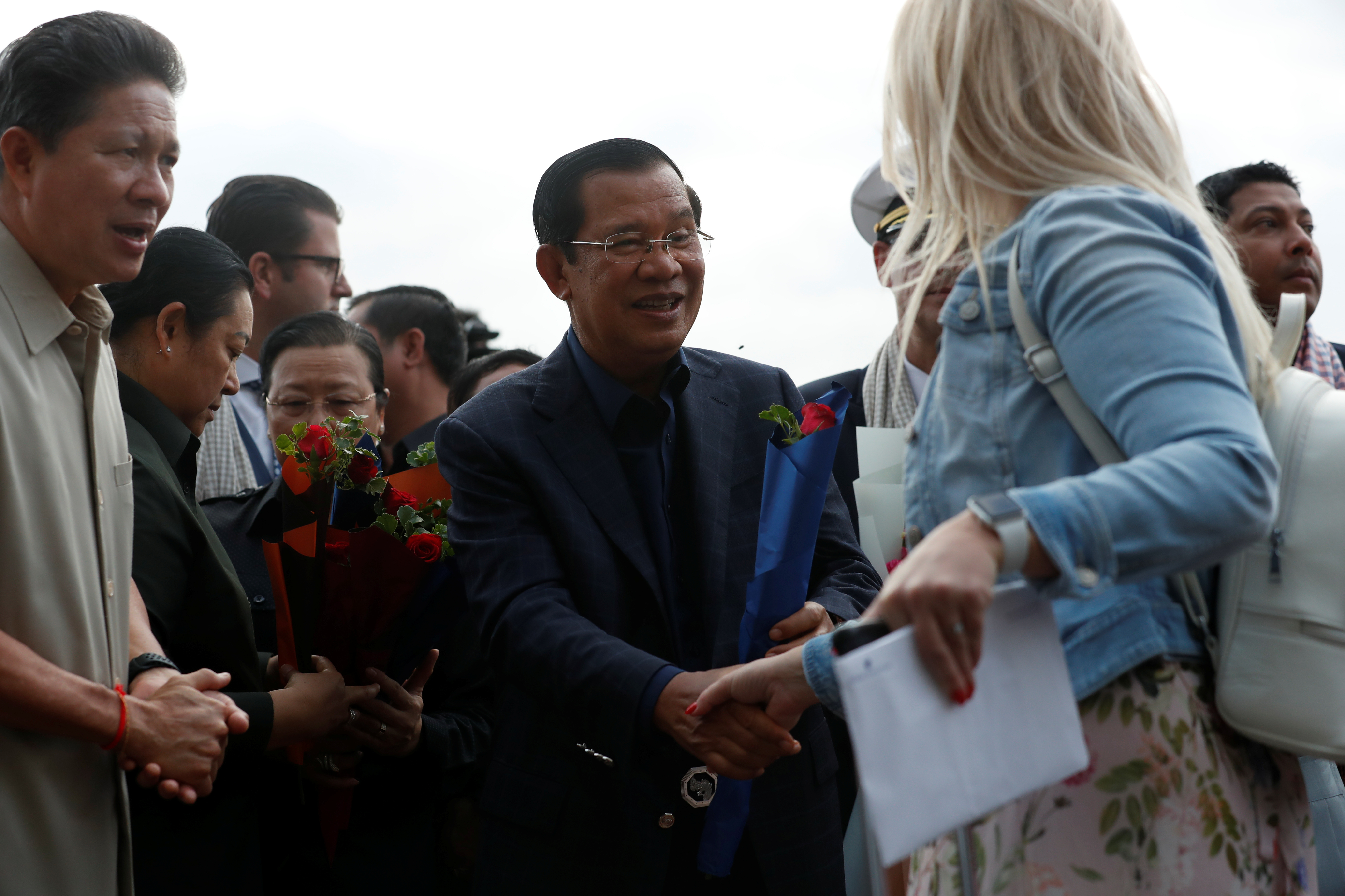 豪华邮轮“威士特丹号”周五在柬埔寨停靠后，柬埔寨首相洪森（中）亲自到场迎接，不但全程没戴口罩，还跟下船乘客握手。-路透社-