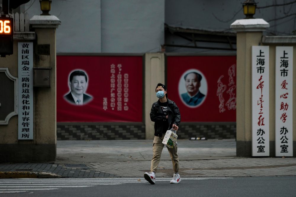 A man wearing a mask walks by portraits of Chinese President Xi Jinping and late Chinese chairman Mao Zedong as the country is hit by an outbreak of the novel coronavirus, on a street in Shanghai, China February 10, 2020. u00e2u20acu201d Reuters pic
