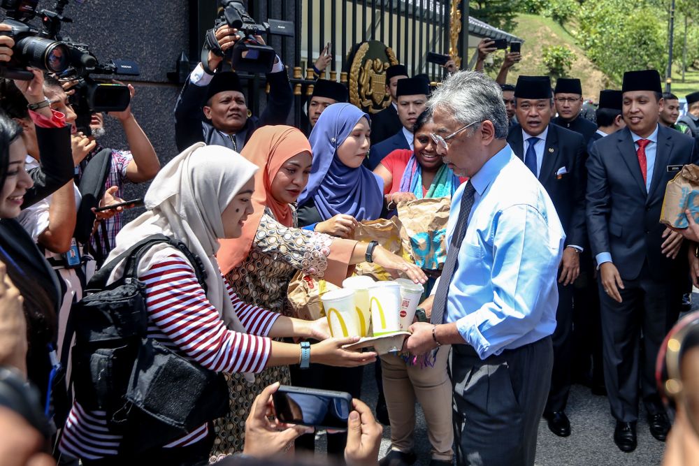 Yang di-Pertuan Agong Al-Sultan Abdullah Ri'ayatuddin Al-Mustafa Billah Shah (centre) distributes food from McDonald's to members of the media at Istana Negara February 25, 2020. u00e2u20acu2022 Picture by Miera Zulyana