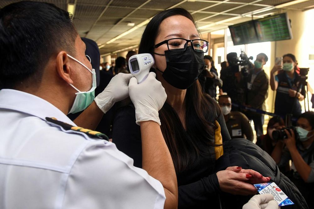 A health worker uses an infrared thermometer to check the temperature of a tourist who arrives at Bangkoku00e2u20acu2122s Don Mueang Airport, Thailand, January 25, 2020. u00e2u20acu201d Reuters pic