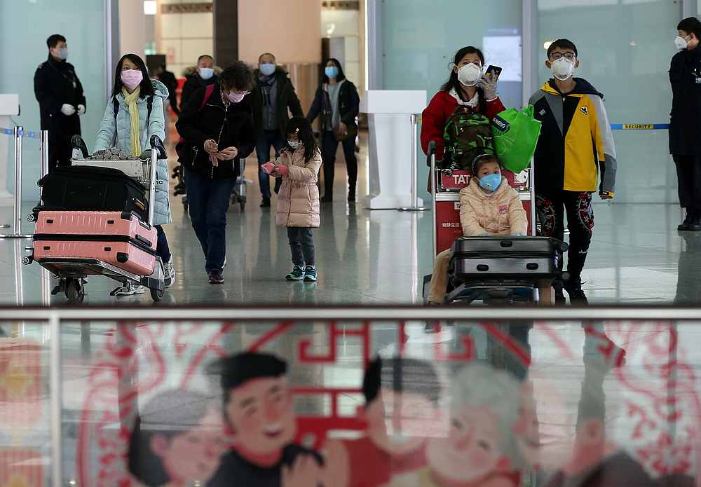 Travellers wearing face masks arrive at the Beijing Capital International Airport as the country is hit by an outbreak of the new coronavirus February 2, 2020. u00e2u20acu201d China Daily pic via Reuter
