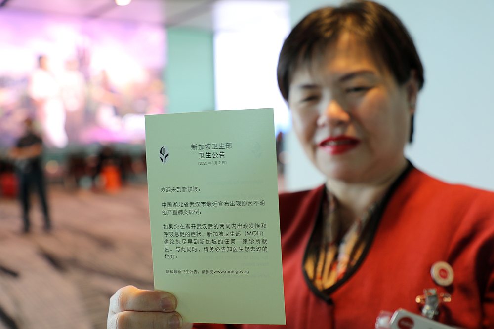An official shows a health pamphlet upon arrival of a flight from Hangzhou, China at Changi Airport, Singapore January 22, 2020. u00e2u20acu201d Reuters pic