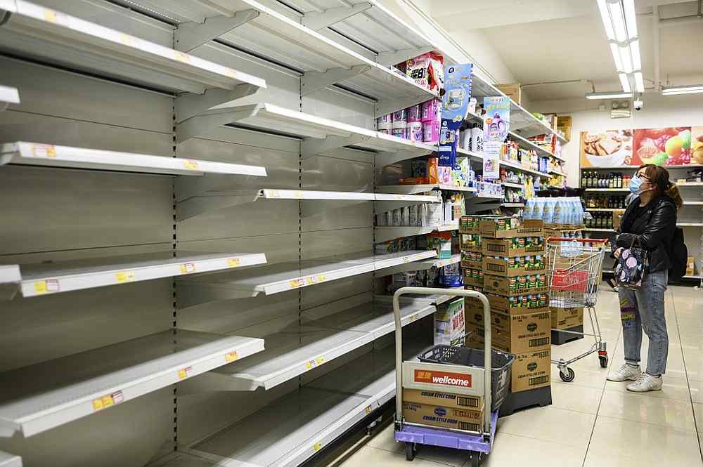 A woman wearing a facemask looks at empty supermarket shelves, which were used for stacking paper towels, in Hong Kong February 5, 2020. u00e2u20acu201d AFP pic