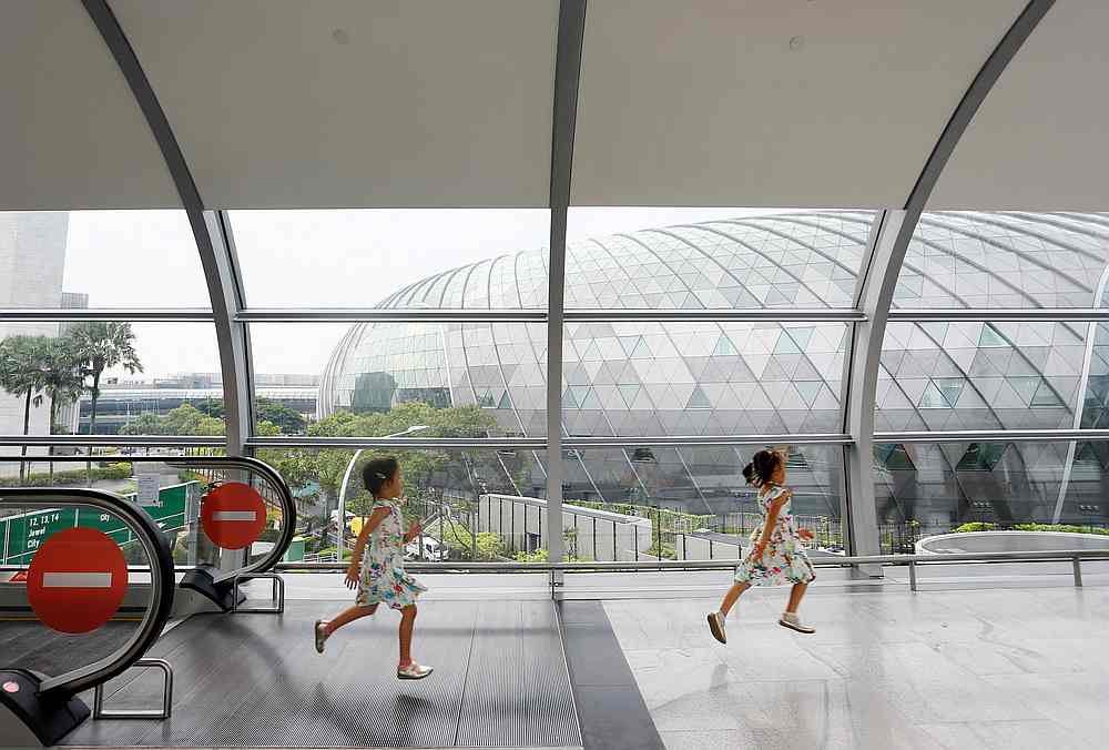 Children run through a walkway that links the various terminals to Jewel Changi Airport in Singapore, April 11, 2019. u00e2u20acu201d Reuters pic 