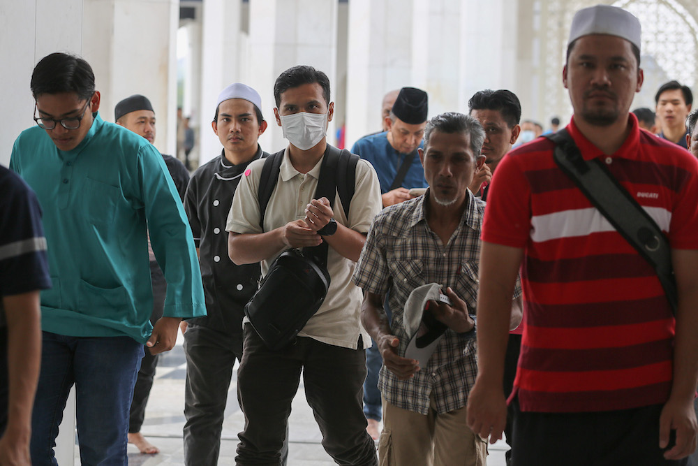 A man wears a protective mask as he attends Friday prayers at Sultan Salahuddin Abdul Aziz Shah Mosque in Shah Alam March 13, 2020. u00e2u20acu201d Picture by Yusof Mat Isa