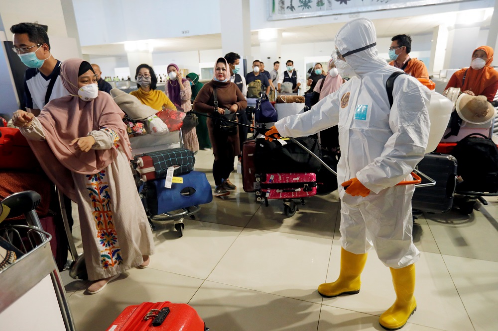 A traveller reacts as a worker sprays disinfectant on passengersu00e2u20acu2122 baggage at the international arrivals terminal of Soekarno-Hatta Airport near Jakarta, amid the coronavirus disease outbreak March 13, 2020. u00e2u20acu201d Reuters pic