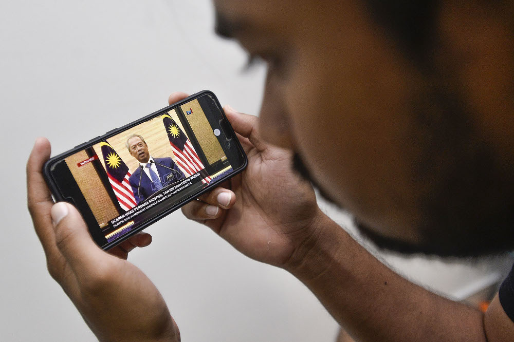 A man watches a live telecast of Prime Minister Tan Sri Muhyiddin Yassin in Shah Alam on March 2, 2020. u00e2u20acu201d Picture by Miera Zulyana