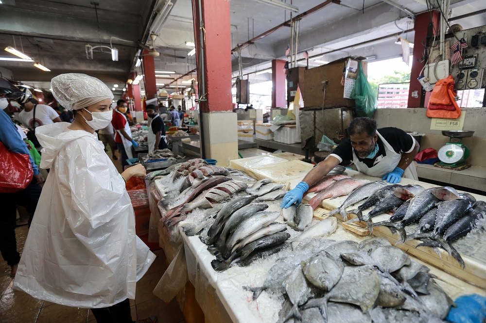 People buying fresh fish at a wet market in Petaling Jaya March 25,2020.  u00e2u20acu201d Picture by Ahmad Zamzahuri