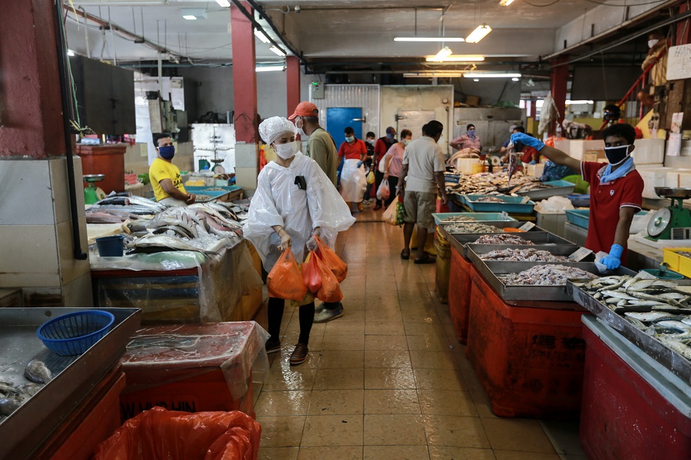 People buying fresh fish at a wet market in Petaling Jaya March 25,2020.  u00e2u20acu201d Picture by Ahmad Zamzahuri
