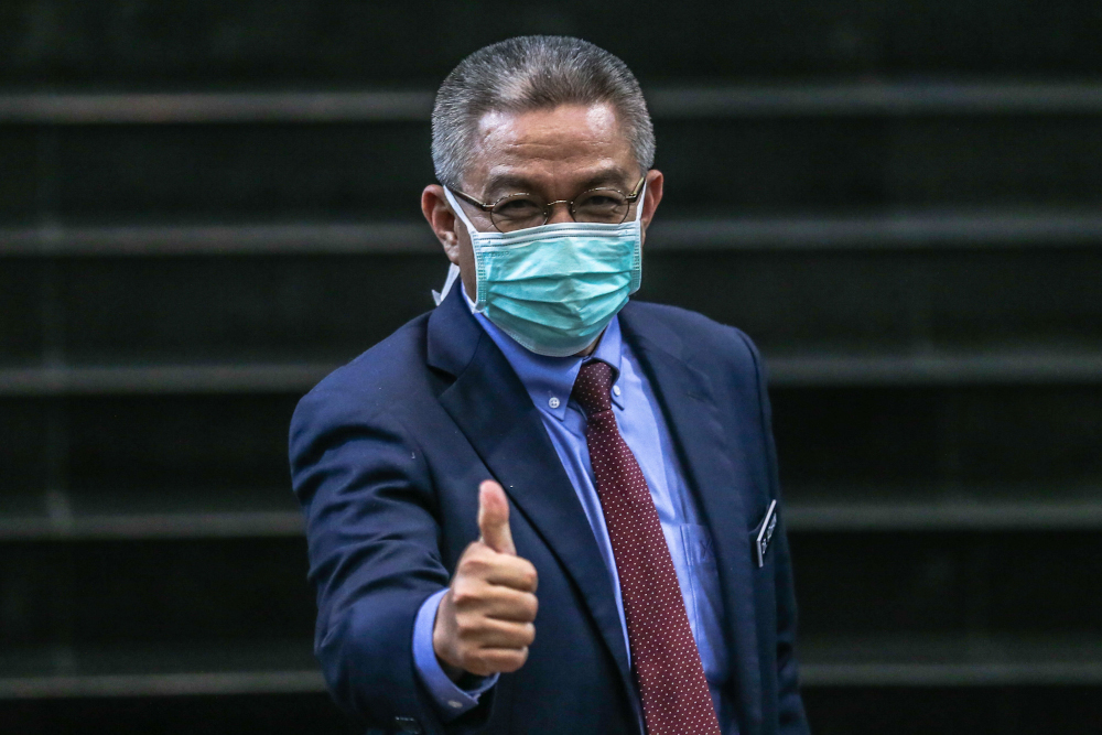 Health Minister Datuk Seri Dr Adham Baba demonstrates the correct way to wear a face mask after a press conference at Hospital Sg Buloh March 12, 2020. u00e2u20acu201d Picture by Firdaus Latif 