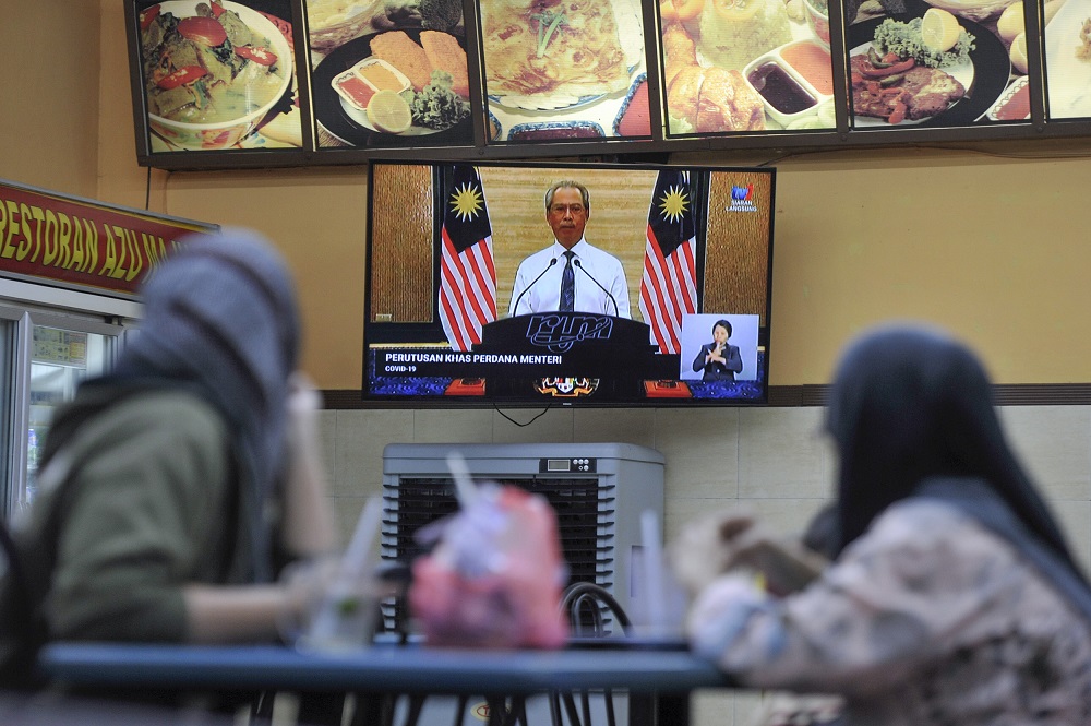 People watching the live telecast of Prime Minister Tan Sri Muhyiddin Yassinu00e2u20acu2122s announcement of a nationwide movement control order due to the Covid-19 pandemic, at a restaurant in Kajang March 16, 2020. u00e2u20acu201d Picture by Shafwan Zaidon