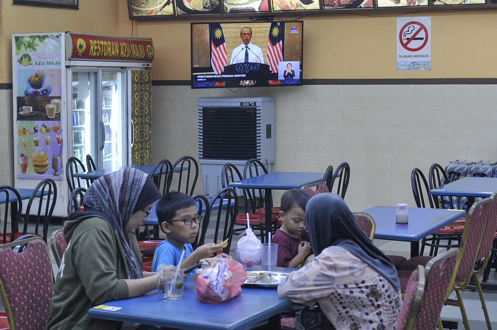 The live telecast of Prime Minister Tan Sri Muhyiddin Yassinu00e2u20acu2122s announcement regarding a nationwide movement control order is shown on a television at a restaurant in Kajang March 16, 2020. u00e2u20acu201d Picture by Shafwan Zaidon