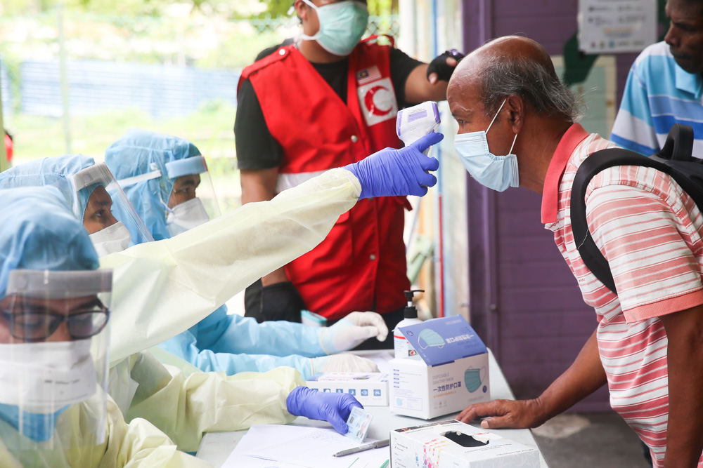 Health Ministry personnel screened individuals for fevers as part of Covid-19 precautions, before sending them to transit centres for the homeless during the MCO March 30, 2020. u00e2u20acu201d Picture by Choo Choy May.
