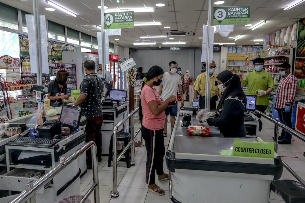Shoppers stand at a distance from each other in a grocery store store in Cheras March 22, 2020. u00e2u20acu201d Picture by Firdaus Latif