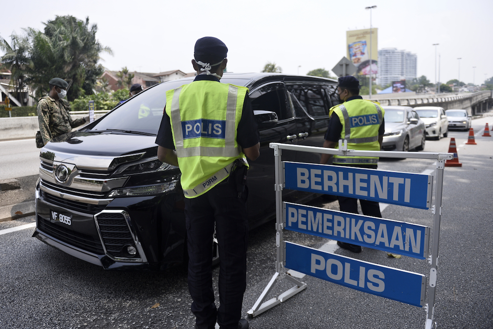 Soldiers and police officers conducting checks at a roadblock on day five of the movement control order (MCO) in Sri Hartamas March 22,2020. u00e2u20acu201d Picture by Miera Zulyana