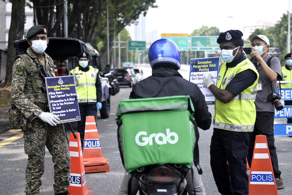 Soldiers and police officers conducting checks at a roadblock on day five of the movement control order (MCO) in Sri Hartamas March 22,2020. u00e2u20acu201d Picture by Miera Zulyana