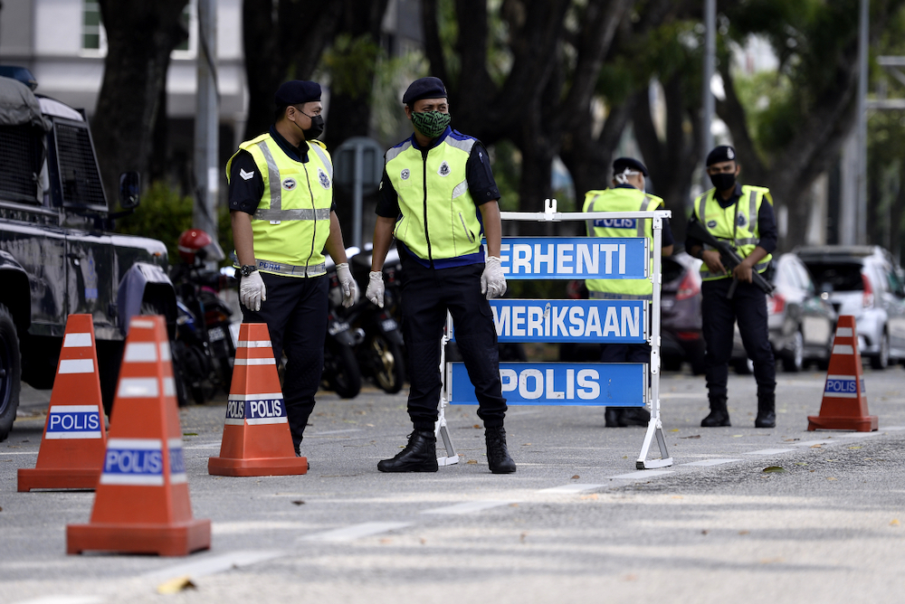 Soldiers and police officers conducting checks at a roadblock on day five of the movement control order (MCO) in Sri Hartamas March 22,2020. u00e2u20acu201d Picture by Miera Zulyana