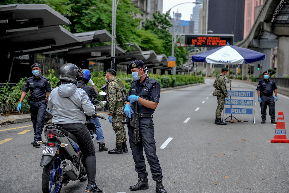 Soldiers and police officers conducting checks at a roadblock during the movement control order (MCO) in Kuala Lumpur March 29, 2020. u00e2u20acu201d Picture by Firdaus Latif