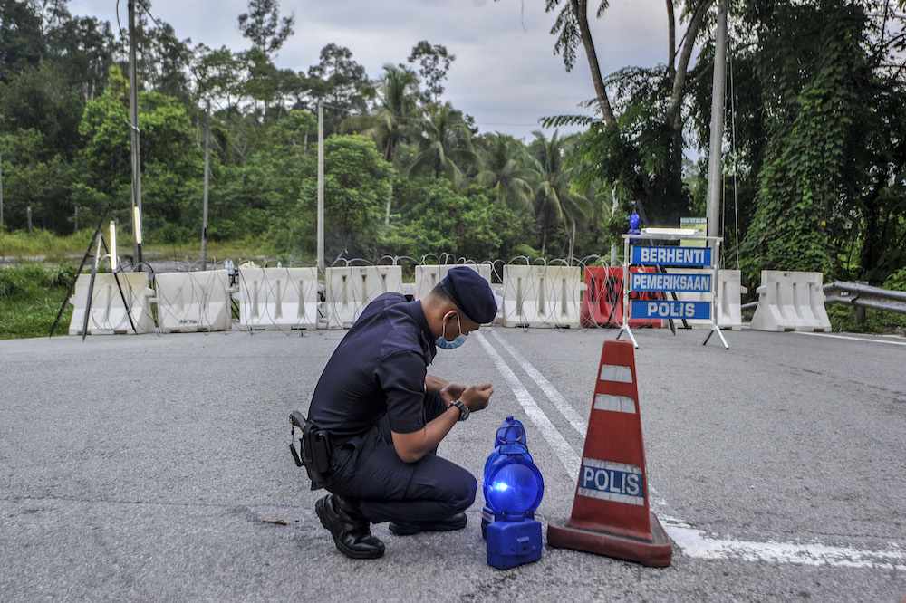 Police officers conducting checks at a roadblock during the enhanced movement control order (EMCO) in seven villages in Hulu Langat, March 30, 2020. u00e2u20acu201d Picture by Shafwan Zaidon