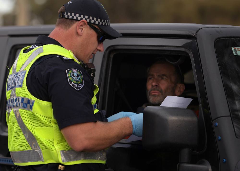 Motorist fills out paperwork for police as he crosses back into South Australia from Victoria during the coronavirus disease outbreak, in Bordertown, Australia March 24, 2020. u00e2u20acu2022 Reuters pic