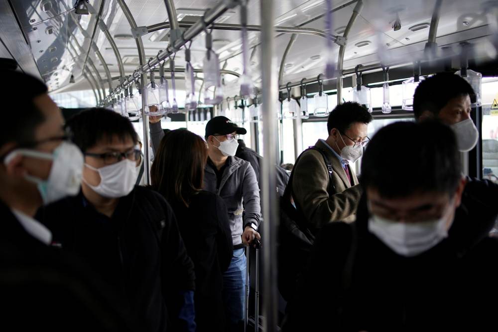 Passengers wearing face masks to prevent the spread of coronavirus disease are seen inside a shuttle bus at Shanghai Hongqiao International Airport in Shanghai March 25, 2020. u00e2u20acu2022 Reuters pic