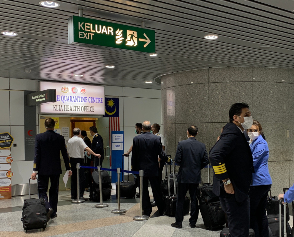 Pilots and crew queue to get cleared at the health check office at the Kuala Lumpur International Airport in Sepang. u00e2u20acu201d Picture by Thasha Jayamanogaran 