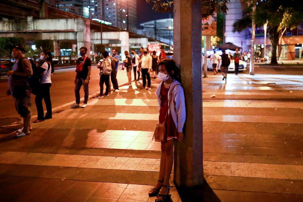 A girl wearing a protective mask, following an outbreak of coronavirus disease (Covid-19), stands on a sidewalk in Manila, Philippines, March 12, 2020. u00e2u20acu201d Reuters picnnn