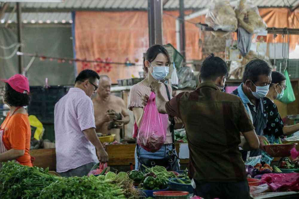 A customer buys vegetables at the Pasar Pinji market in Ipoh March 20, 2020. u00e2u20acu201d Picture by Farhan Najib