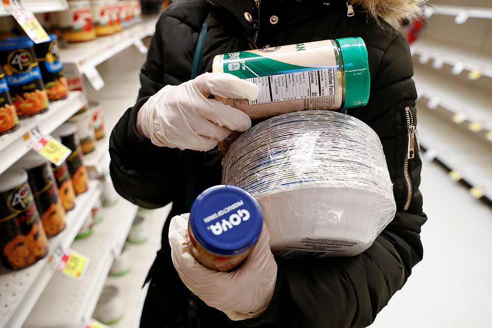 A woman in rubber gloves shows purchases, after further cases of coronavirus were confirmed in New York, at a Stop & Shop store in Port Washington, New York March 14, 2020. u00e2u20acu201d Reuters pic