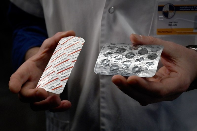 Medical staff at the IHU Mediterranee Infection Institute in Marseille, France hold packets of a Nivaquine, tablets containing chloroquine and Plaqueril. u00e2u20acu2022 AFP pic