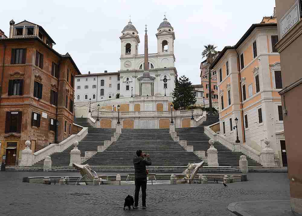 A man uses his smart phone in an empty Via Condotti street in Rome, Italy March 14, 2020. u00e2u20acu201d Reuters pic