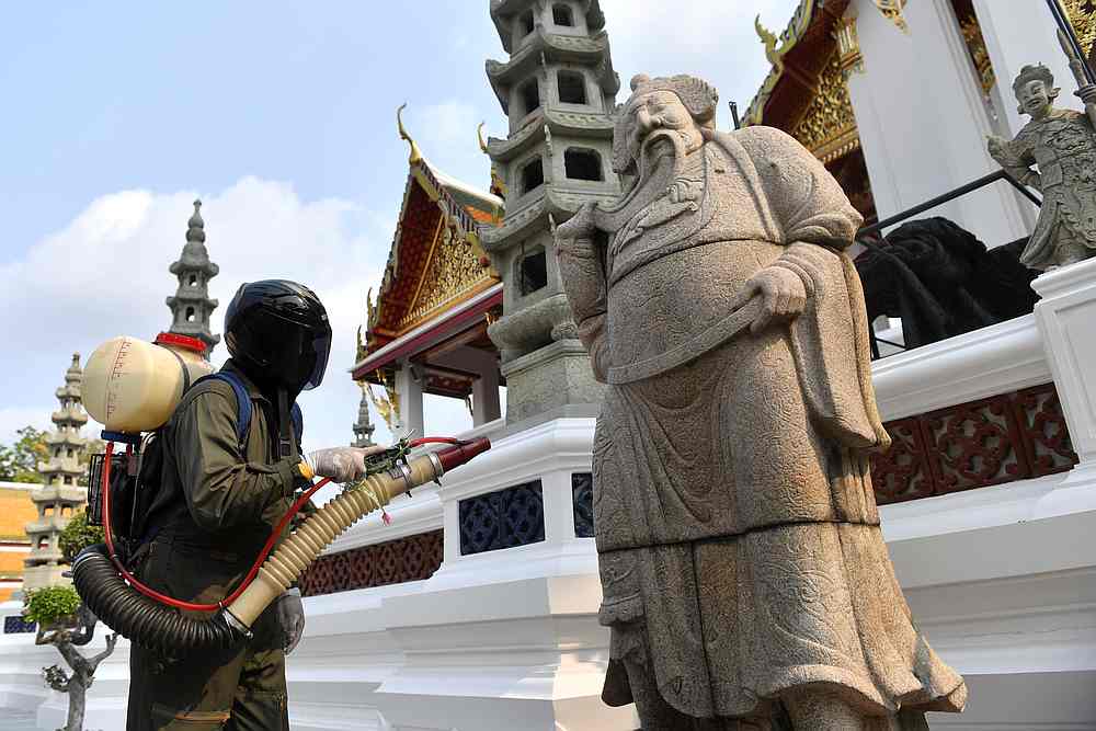 A health worker sprays disinfectant due to the outbreak of Covid-19 at inside Wat Suthat Thepwararam temple in Bangkok, Thailand March 17, 2020. u00e2u20acu201d Reuters pic