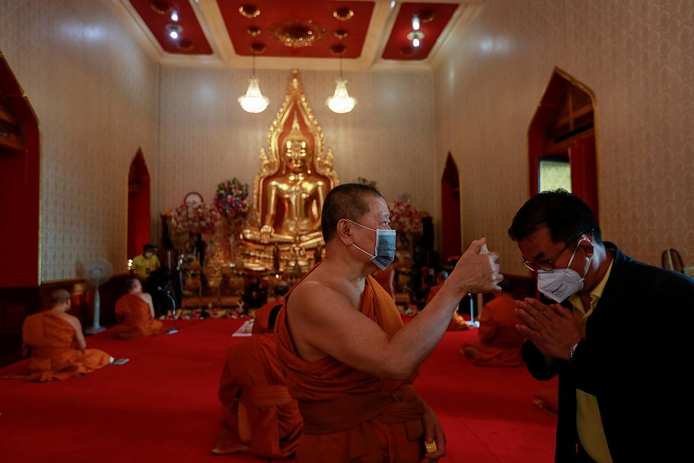 A Buddhist monk sanitises a man before he prays during a blessing ceremony at a temple in Bangkok, Thailand March 25, 2020. u00e2u20acu201d Reuters pic