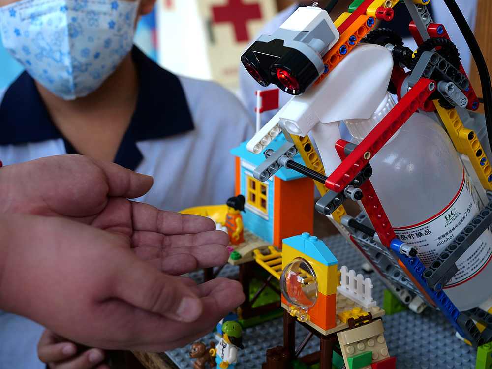An elementary school student uses a self-built motion sensor controlled disinfectant dispenser assembled with Lego parts in Kaohsiung, southern Taiwan March 9, 2020. u00e2u20acu201d Reuters pic