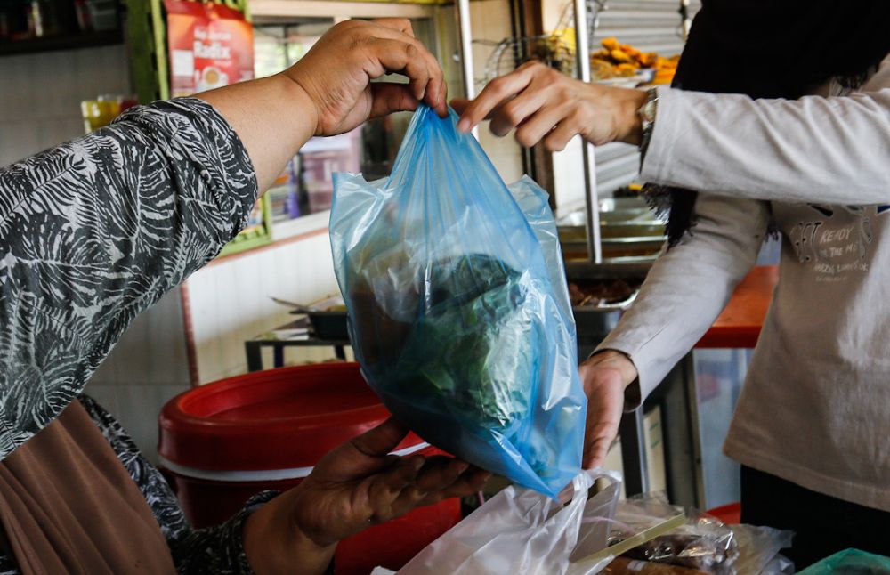 Customers pack food to go at a food court in Penang March 18, 2020. u00e2u20acu201d Picture by Sayuti Zainudin