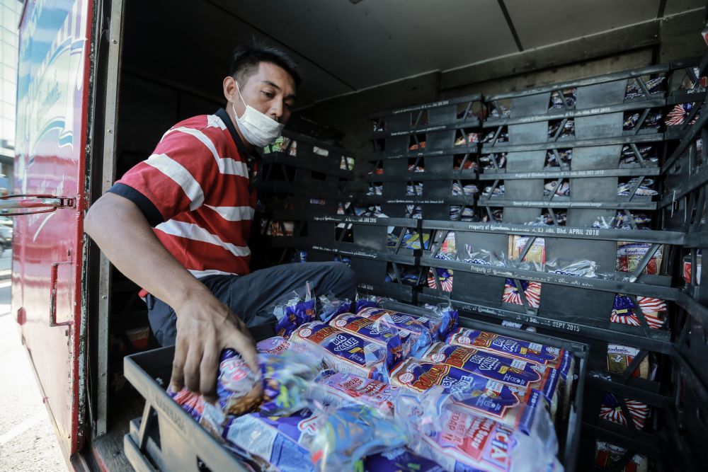 A Gardenia staff unloads fresh loaves of bread at a convenience store in Petaling Jaya March 25, 2020. u00e2u20acu201d Picture by Ahmad Zamzahuri