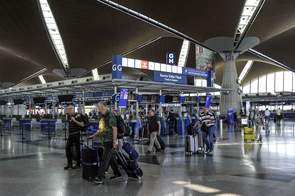 Travellers are pictured at the Kuala Lumpur International Airport in Sepang March 18, 2020. u00e2u20acu201d Picture by Shafwan Zaidon