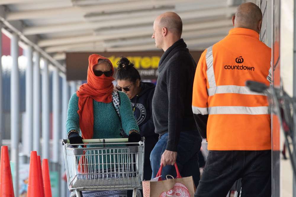 A woman (left) with her face covered waits enter a supermarket to buy supplies one day before the country goes on lockdown to stop any progress of the Covid-19 coronavirus, in Wellington March 24, 2020. u00e2u20acu2022 AFP pic