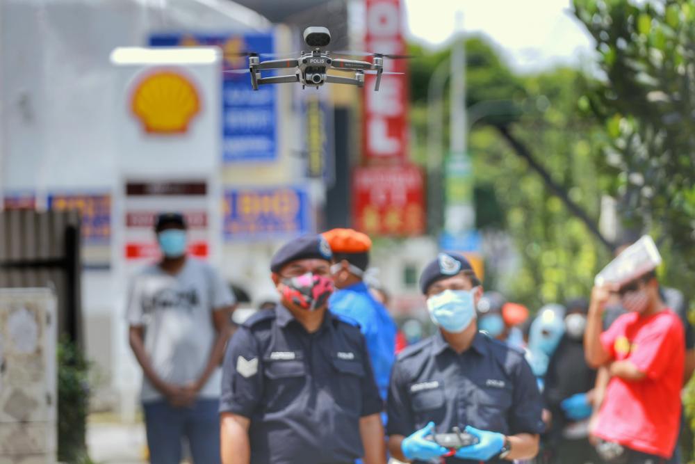 A drone is used by Malaysian police to monitor social distancing at the Chow Kit market in Kuala Lumpur March 27, 2020. u00e2u20acu2022 Picture by Ahmad Zamzahuri