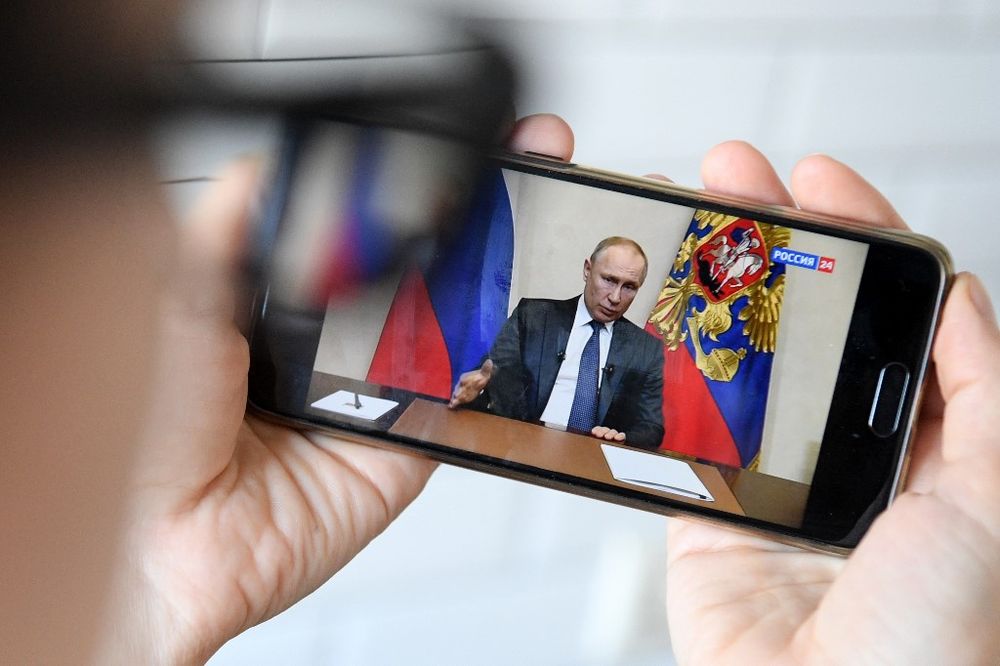 A woman watches a live broadcast of Russian President Vladimir Putinu00e2u20acu2122s address to the nation over the coronavirus outbreak, in Moscow, March 25, 2020. u00e2u20acu201d AFP pic